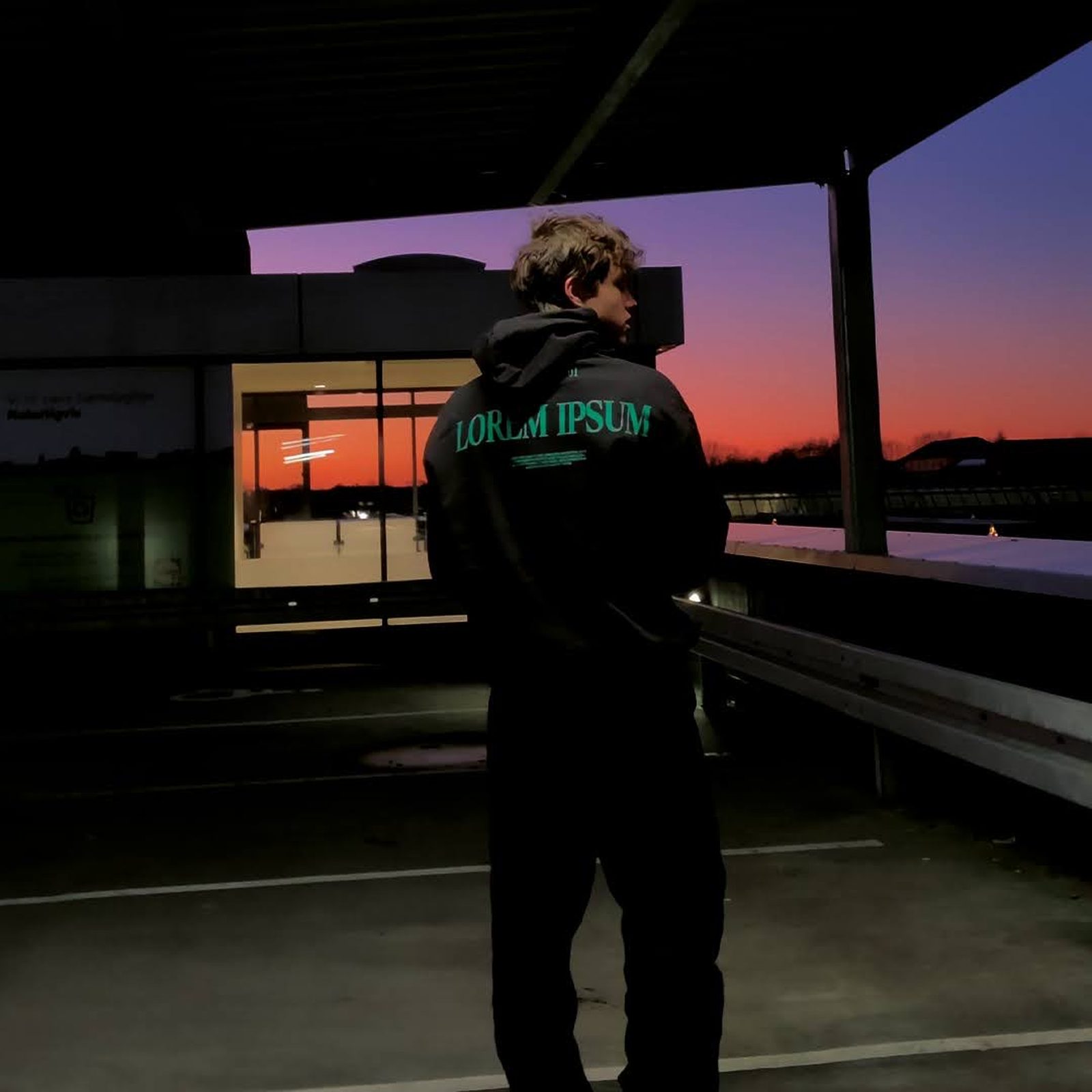 The black LOREM IPSUM jacket against a sunset